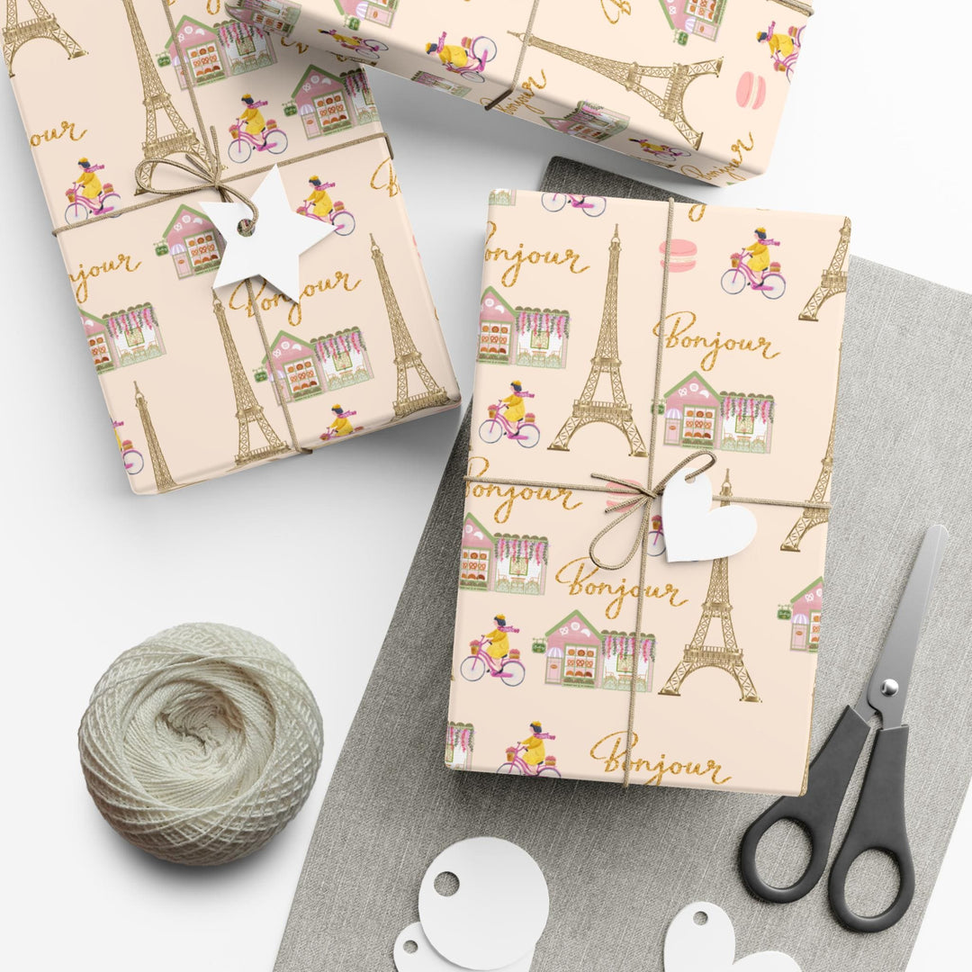 Elegant Paris themed wrapping paper in beige with super cute and fun graphics of a gold Eiffel Tower, adorable French bakery that has florals on the roof of it, &quot;bonjour&quot; text, woman riding her bicycle, pink macaroon