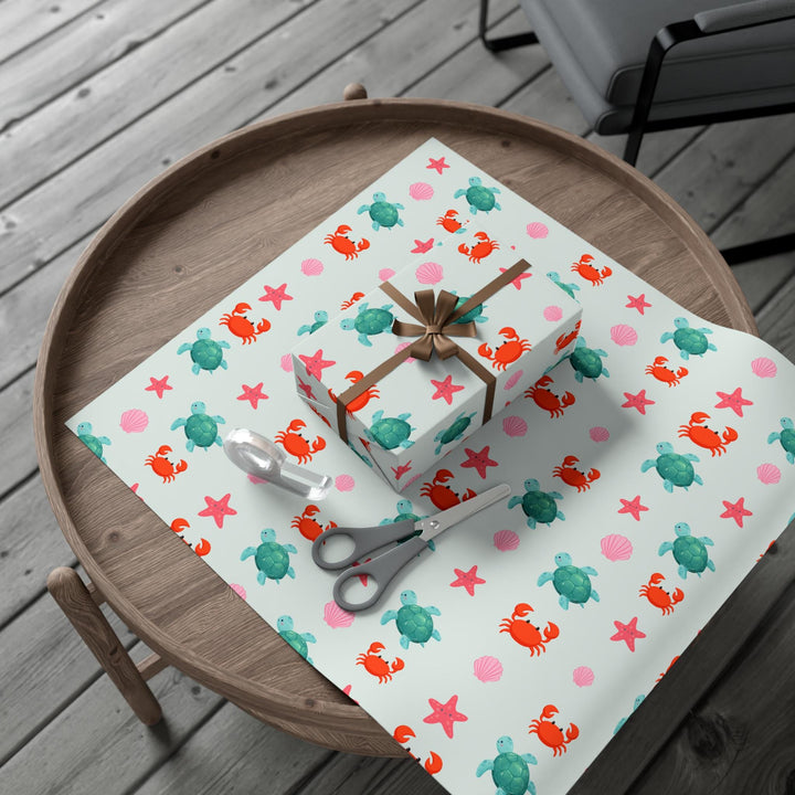 off white background with cute graphics of smiling sea creatures-sea turtle, crab, starfish, pink seashell on wrapping paper!