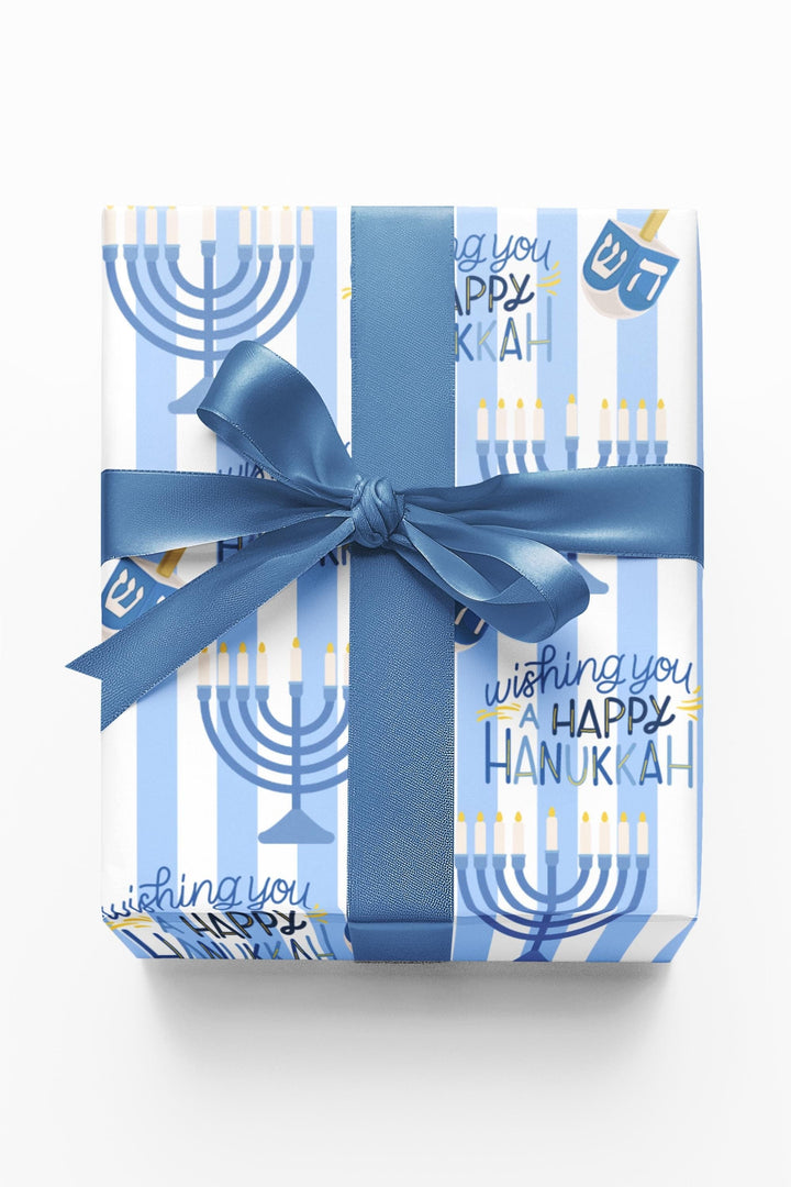 Blue striped wrapping paper with Wishing you a happy Hanukkah text, a graphic of a menorah and dreidel in a varied pattern!