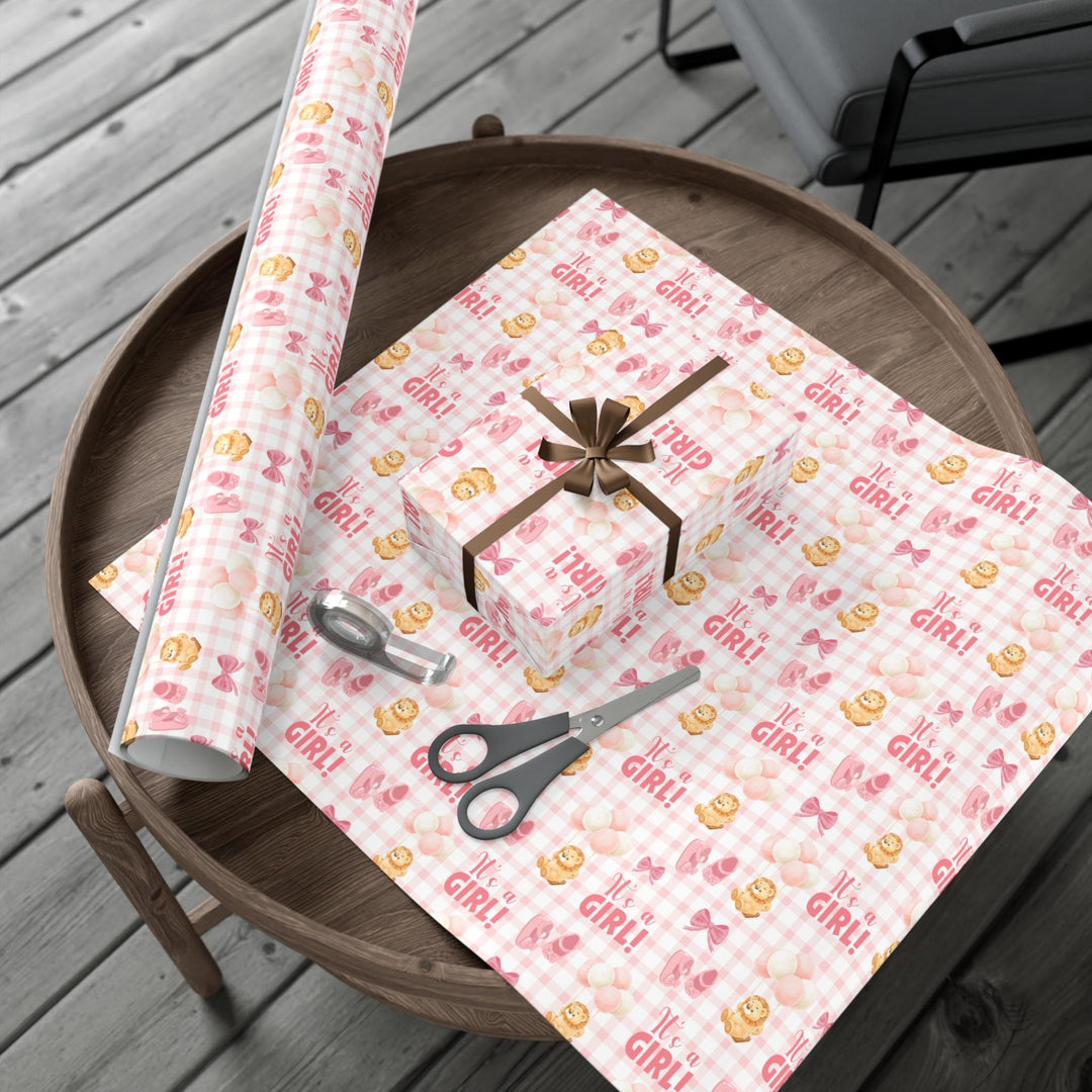 Pink gingham wrapping paper with graphics of lion with balloons, baby ballet flats, baby pink bow and It&#39;s a Girl text