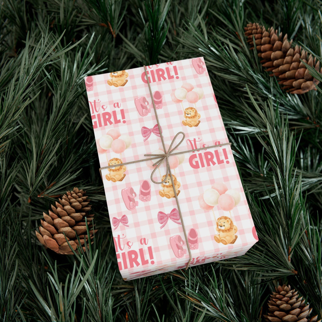 Pink gingham wrapping paper with graphics of lion with balloons, baby ballet flats, baby pink bow and It&#39;s a Girl text