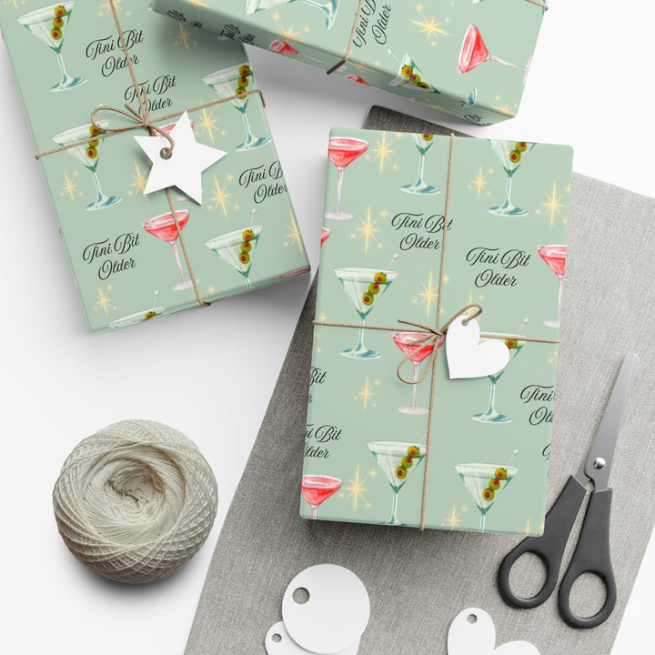 Green wrapping paper with martini glasses and Tini Bit Older text