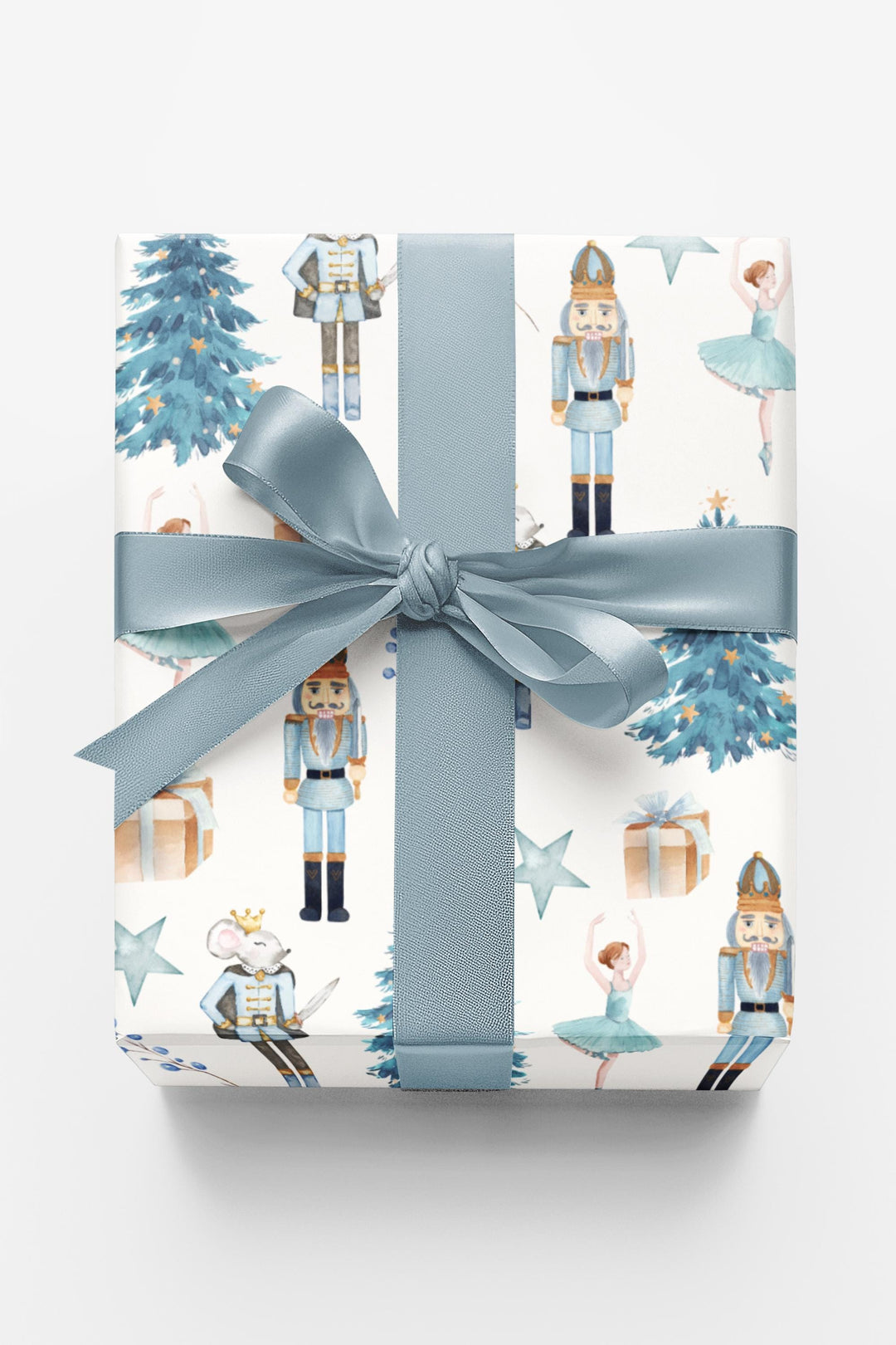 christmas theme wrapping paper blue graphics of a blue christmas tree, blue ballerina, blue nutcracker, blue mouse nutcracker graphic, blue star, blue present, blue florals on a white background