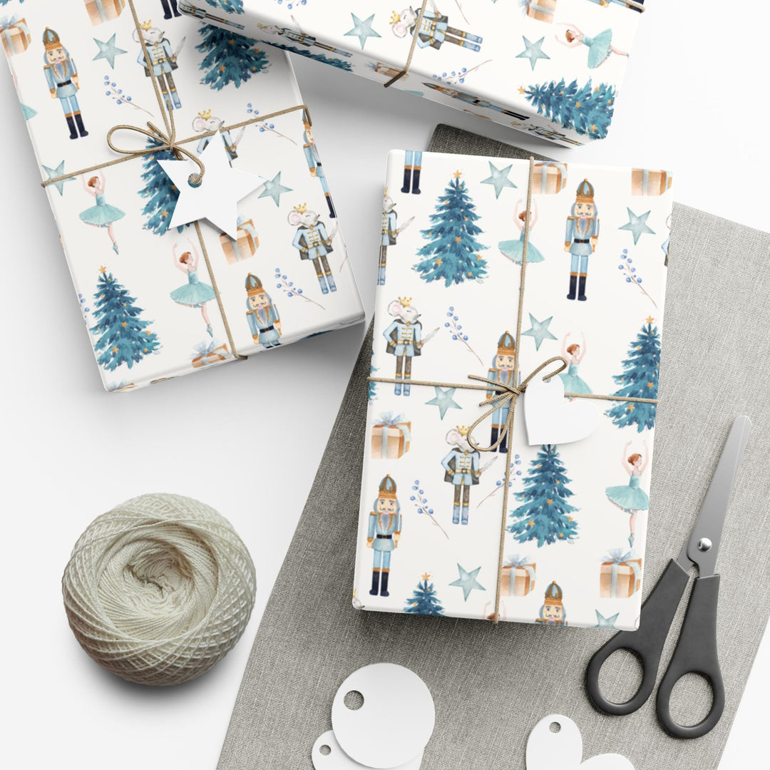 christmas theme wrapping paper blue graphics of a blue christmas tree, blue ballerina, blue nutcracker, blue mouse nutcracker graphic, blue star, blue present, blue florals on a white background