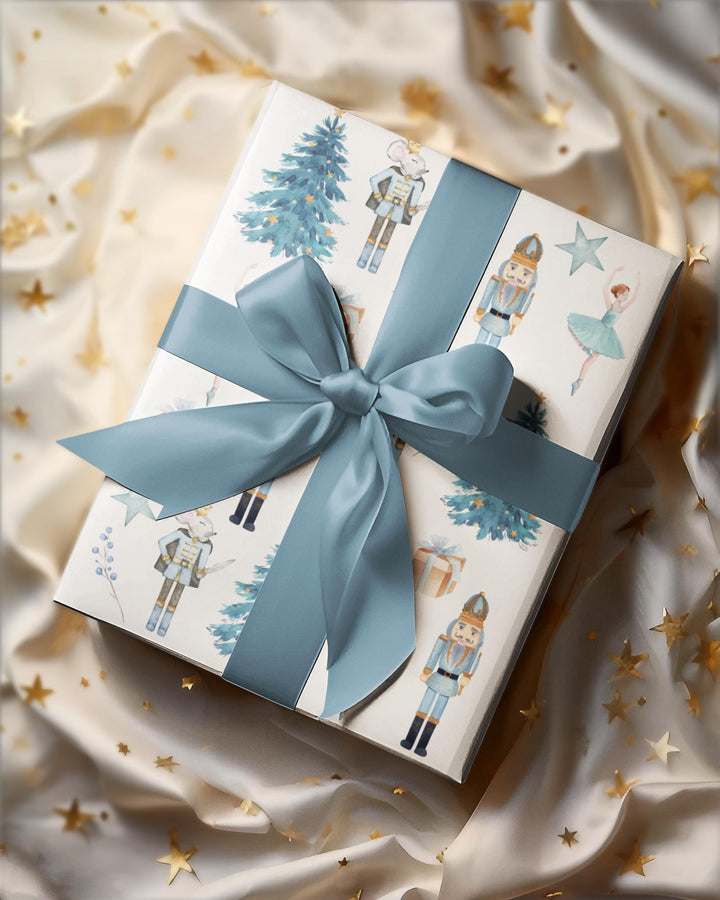 christmas theme wrapping paper blue graphics of a blue christmas tree, blue ballerina, blue nutcracker, blue mouse nutcracker graphic, blue star, blue present, blue florals on a white background