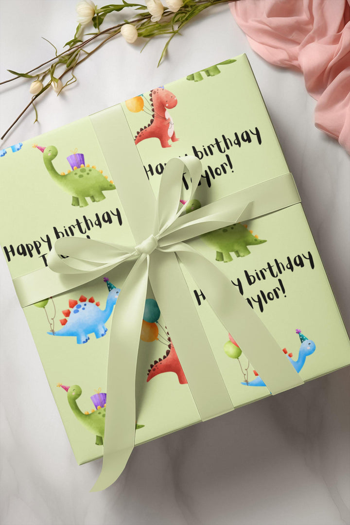 Green wrapping paper with dinosaur fun cute graphics with birthday hats and balloons and personalized happy birthday text