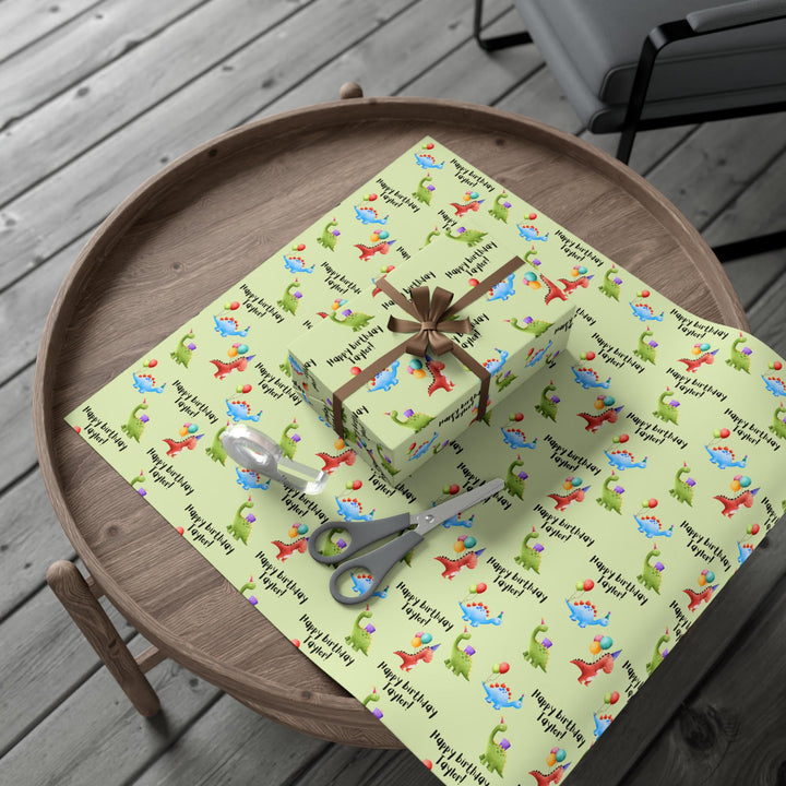 Green wrapping paper with dinosaur fun cute graphics with birthday hats and balloons and personalized happy birthday text