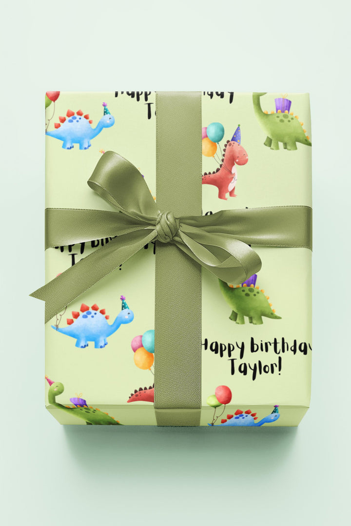 Green wrapping paper with dinosaur fun cute graphics with birthday hats and balloons and personalized happy birthday text