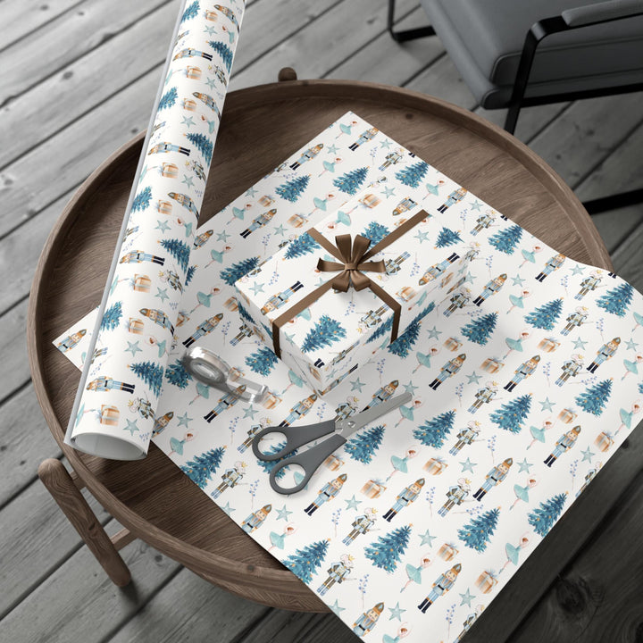 christmas theme wrapping paper blue graphics of a blue christmas tree, blue ballerina, blue nutcracker, blue mouse nutcracker graphic, blue star, blue present, blue florals on a white background