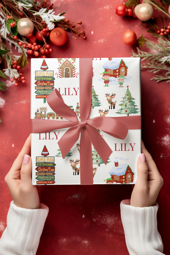 North Pole themed wrapping paper with graphics of elf village, peppermint house , North Pole signs, christmas trees and reindeers, candy cane village, christmas tree forest, peppermint mine personalized with a name