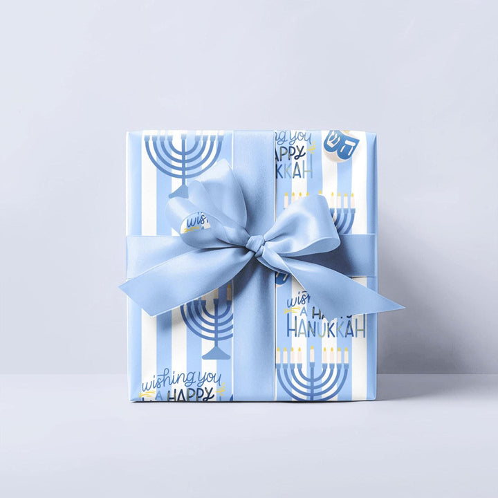 Blue  and white striped wrapping paper pattern with Hanukkah menorahs dreidels and wishing you a happy Hanukkah text