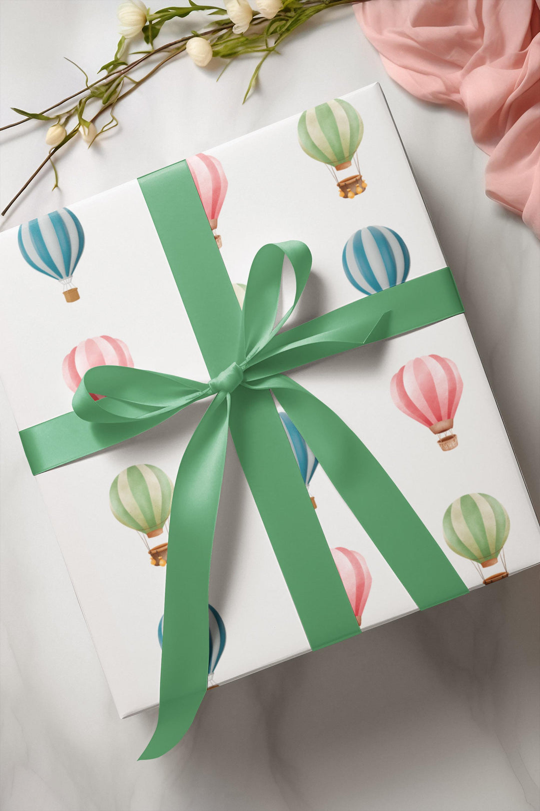 White wrapping paper with cute graphics of hot air balloons in different colors- green blue and pink !