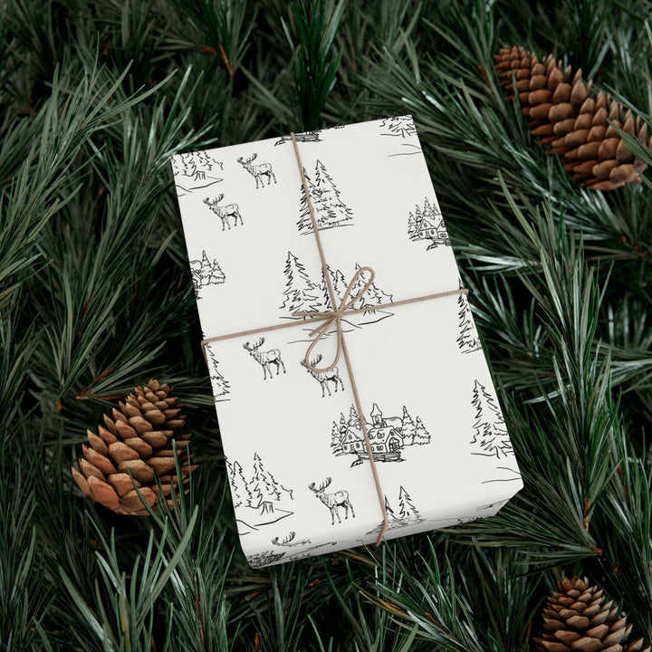 off white background with black silhouettes of christmas trees and  town and christmas log cabin with reindeer graphics- elegant and understated but beautiful and classic
