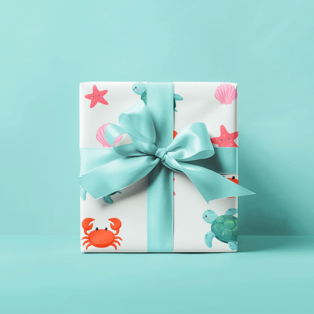 off white background with cute graphics of smiling sea creatures-sea turtle, crab, starfish, pink seashell on wrapping paper!