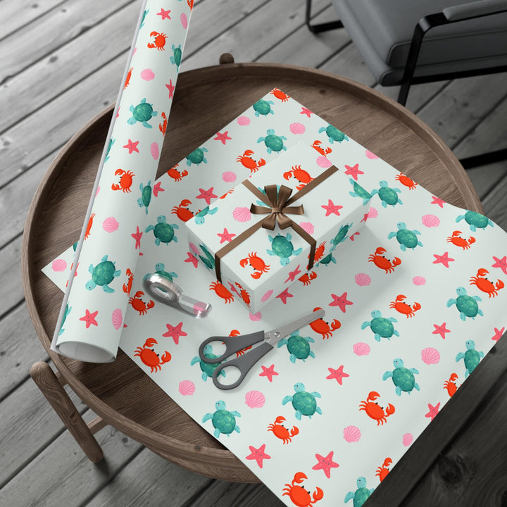 off white background with cute graphics of smiling sea creatures-sea turtle, crab, starfish, pink seashell on wrapping paper!