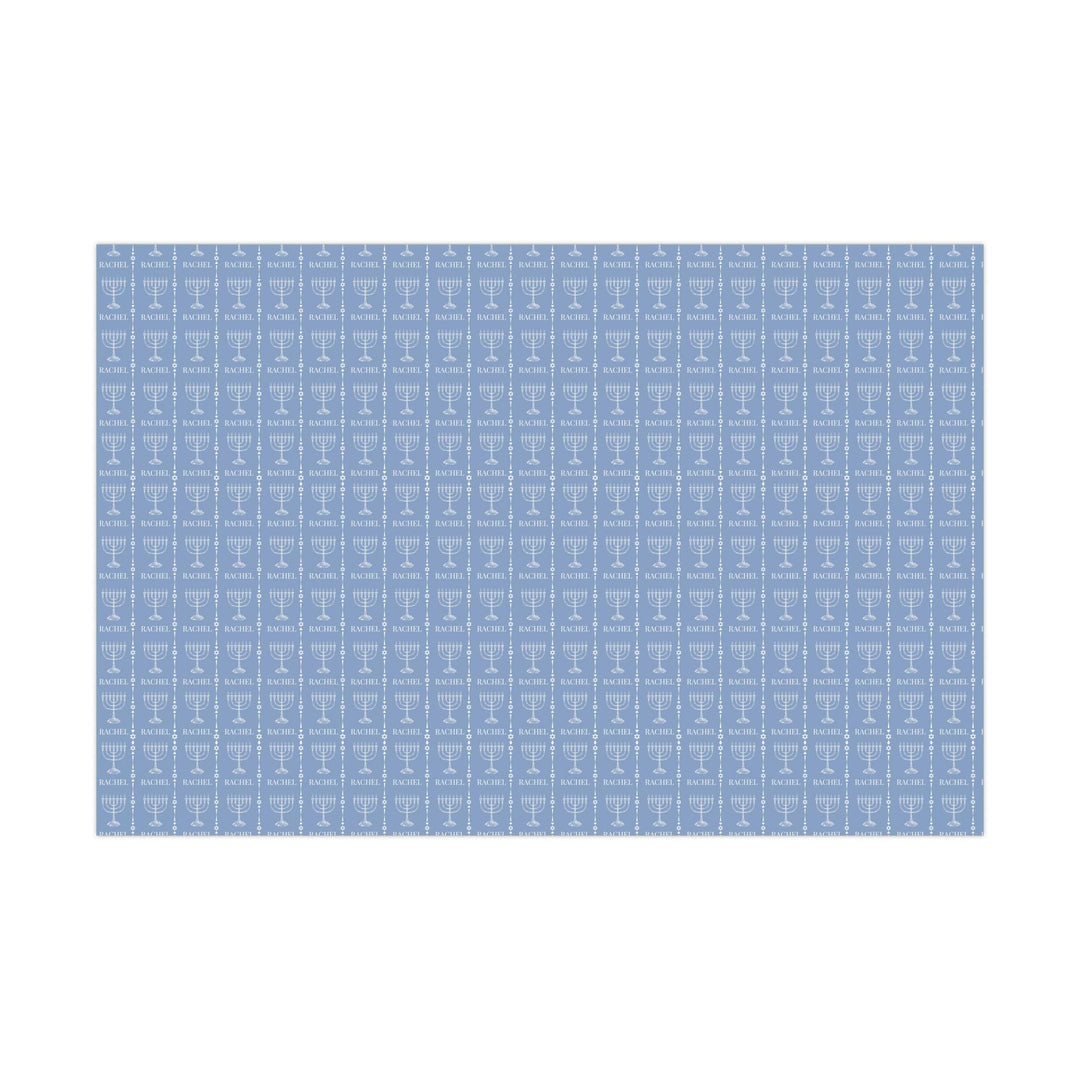 Light blue wrapping paper with white custom name and white menorah graphic and white jewish star graphic