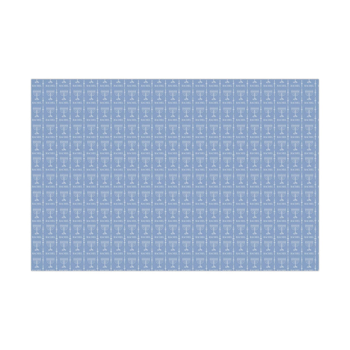 Light blue wrapping paper with white custom name and white menorah graphic and white jewish star graphic