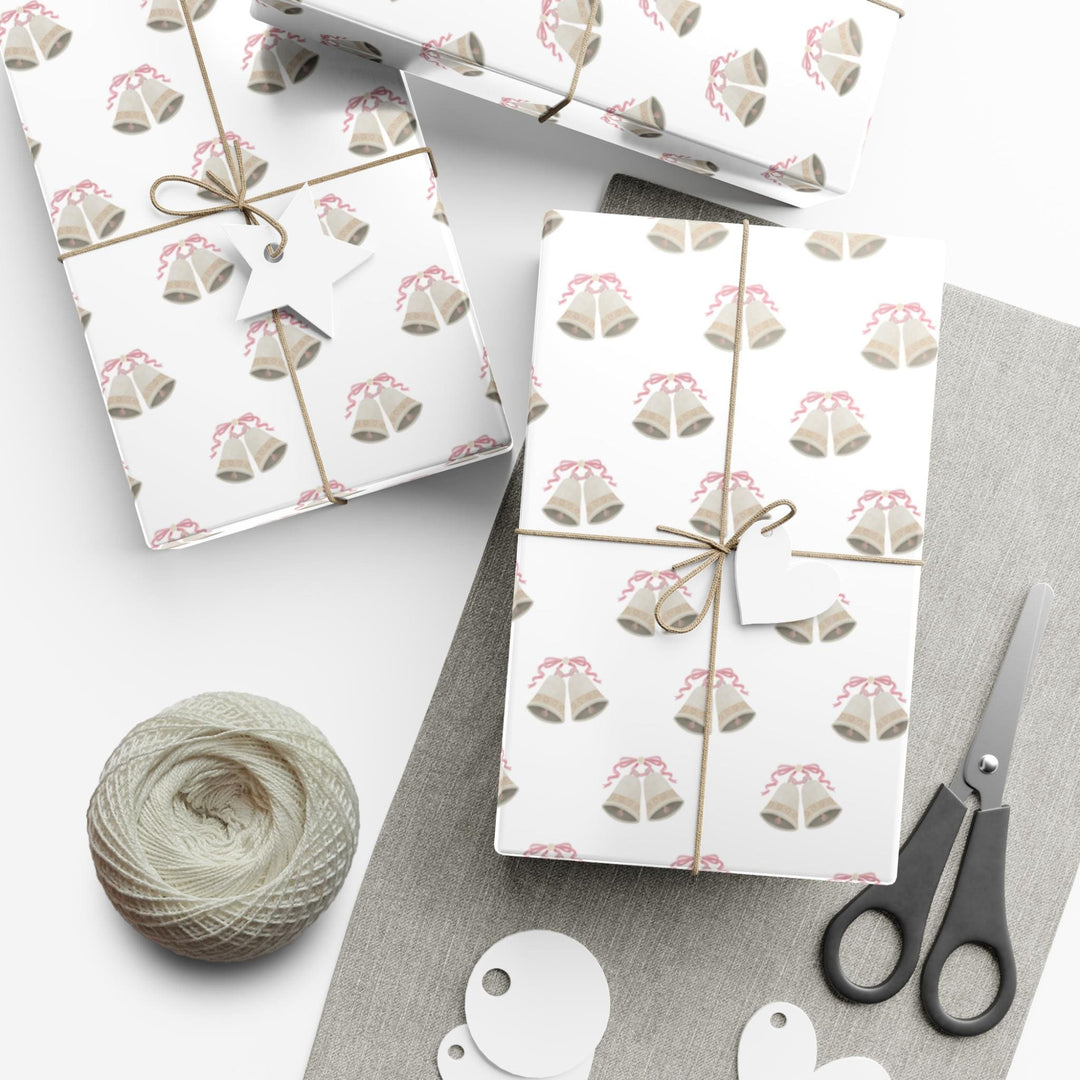 white wrapping paper with wedding bells with pink ribbon bows