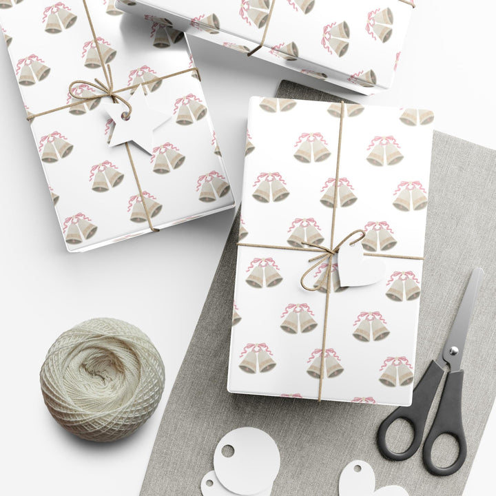 white wrapping paper with wedding bells with pink ribbon bows