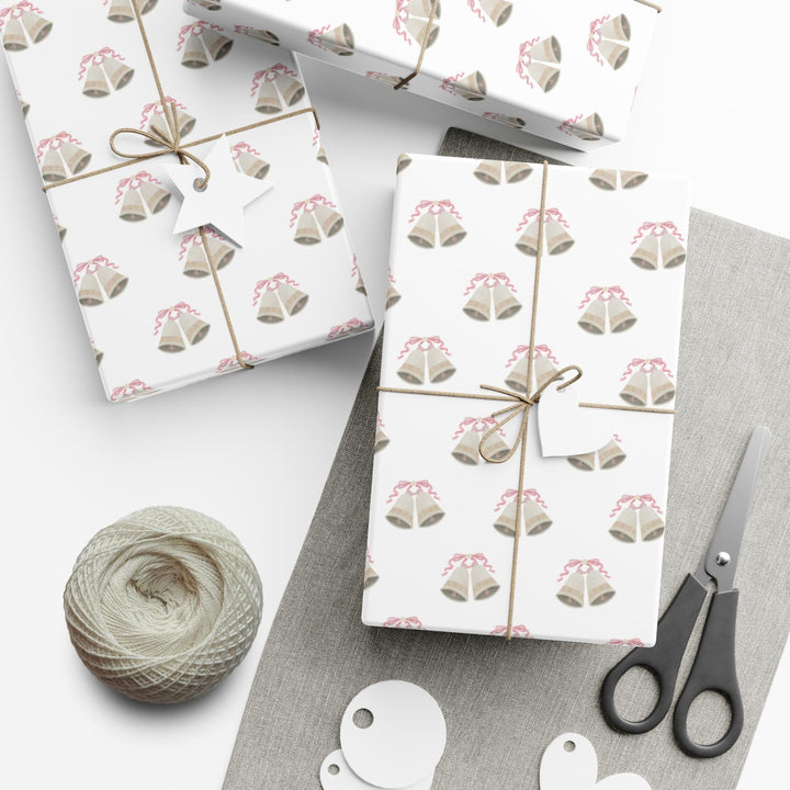 white wrapping paper with wedding bells with pink ribbon bows