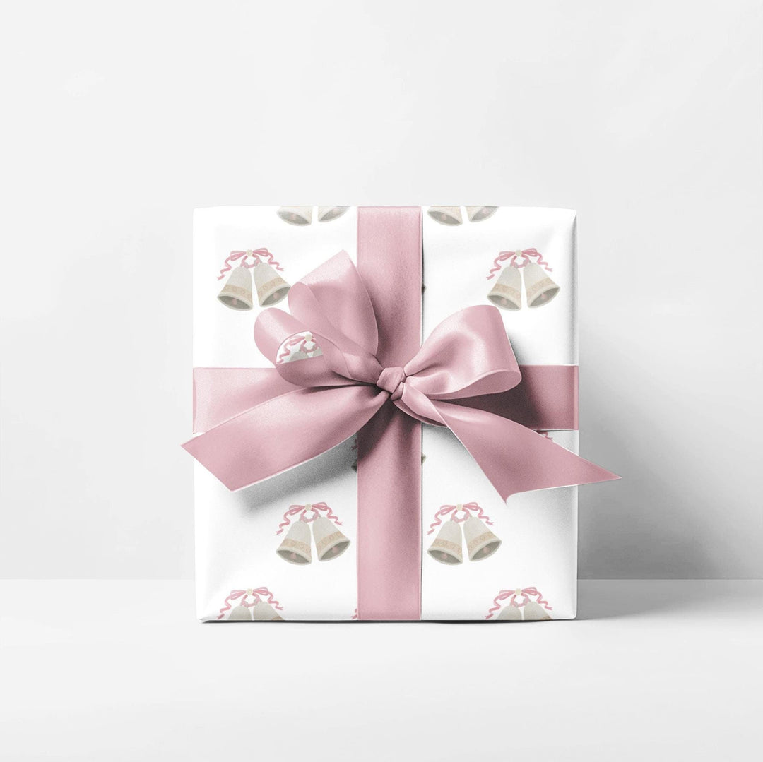 white wrapping paper with wedding bells with pink ribbon bows