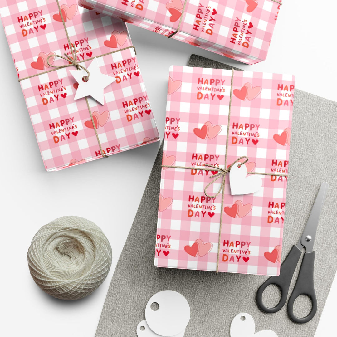 Happy valentines day wrapping paper on pink gingham background with pink hearts