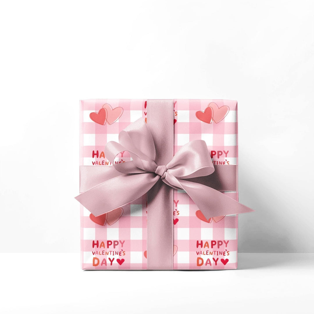 Happy valentines day wrapping paper on pink gingham background with pink hearts